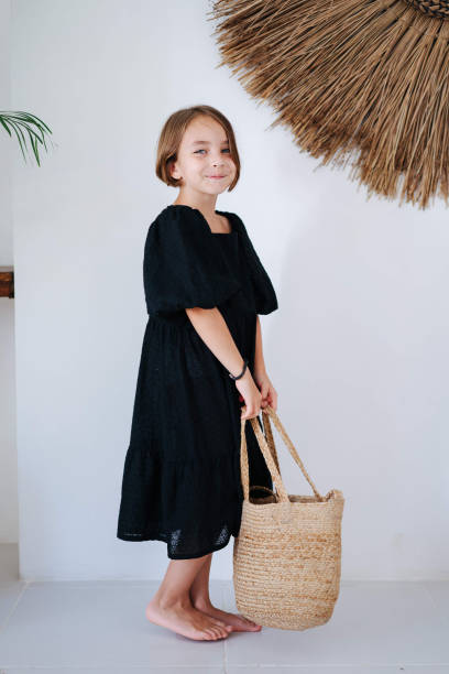 Girl in a summer interior holds a wicker bag