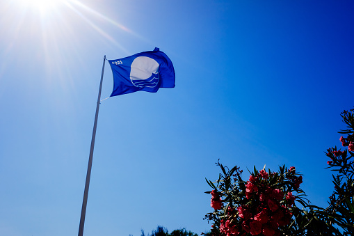 Valencia, Spain - July 6, 2021: The blue flag is a badge that is awarded to the best beaches of the highest quality on the Spanish coast.