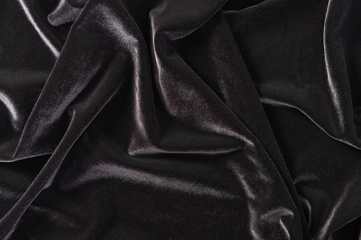 A background of crumpled black velvet with a luxurious sheen.