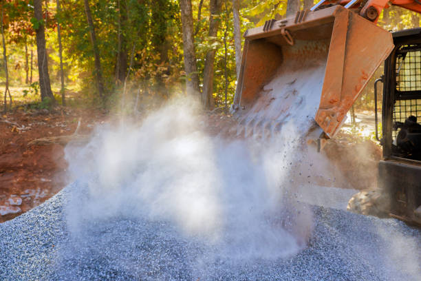 Using tractor, prepare basis for new road by laying crushed stone gravel which has been filled