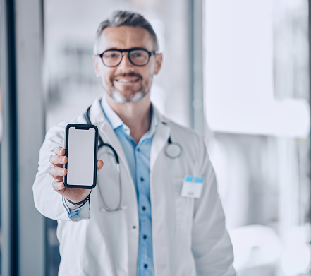 Doctor, phone screen and mockup for healthcare presentation, communication or FAQ in hospital. Medical portrait of man with mobile app, advertising or ux design space for contact us or clinic sign up