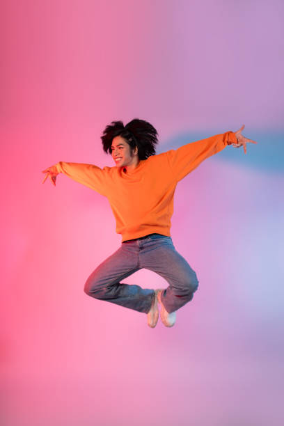 istock Image of a young Asian person dancing on a neon colored background 1715064435