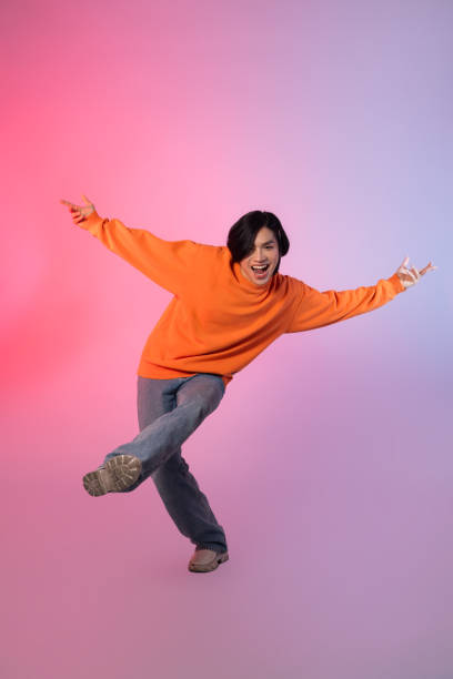 istock Image of a young Asian person dancing on a neon colored background 1715064473