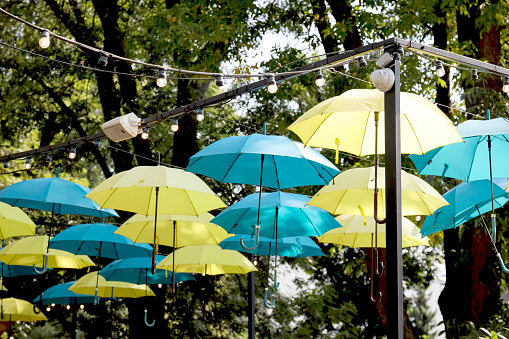 Warsaw, Poland - September 12, 2023: Blue and yellow umbrellas offer protection from the sun above a cafe in the Saska Kepa housing estate in the Praga-Poludnie district.