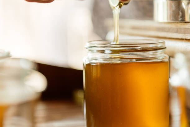 istock The liquid fresh honey is filled into glasses 1715069466