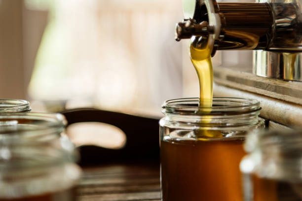 istock The liquid fresh honey is filled into glasses 1715070034