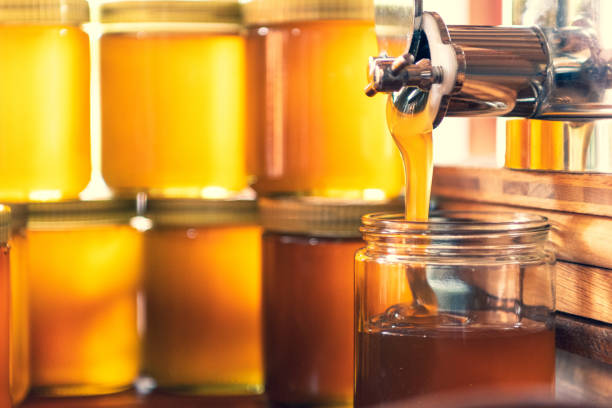 istock The liquid fresh honey is filled into glasses 1715070035