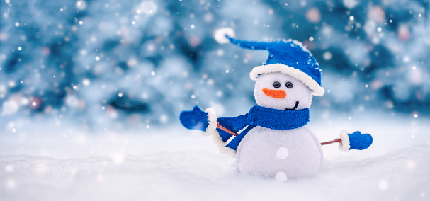 Little handmade snowman on the white snow on blue background. Beautiful panoramic view.