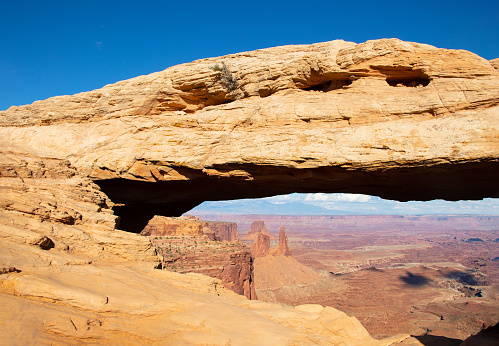 Young Caucasian woman standing on natural stone bridge in Wadi Rum desert