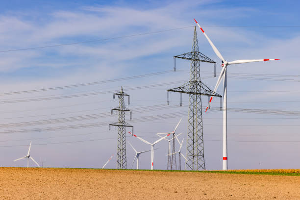 istock Several wind turbines and power poles on a field under blue sky 1715122990