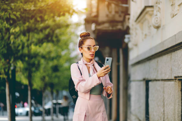 Elegant beautiful woman standing with smart phone Elegant beautiful woman standing with smart phone victoria house stock pictures, royalty-free photos & images