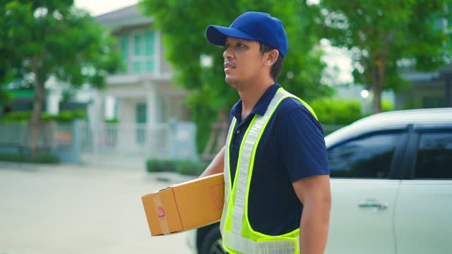 Delivery man take package box from transport van and carry to customer at home.