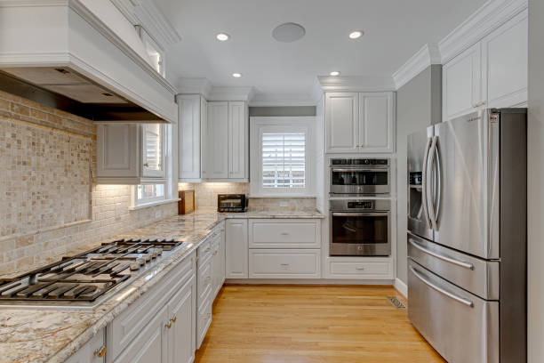 istock Modern Clean Luxury White Kitchen with Stovetop with Backsplash and Stainless Steel Appliances with Hardwood Floors and Plantation Shutters 1715163743
