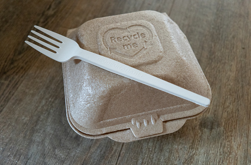 A recyclable take away food container, with a biodegradable fork.  The new packaging is part of the fast food industry efforts to cut back on plastic packaging.  It coincides with the UK law banning  single-use disposable food packaging coming into force in October 2023.