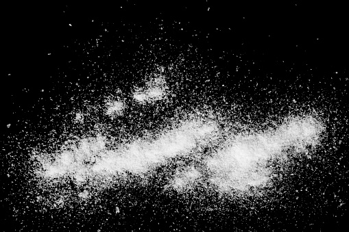 Abstract background of white powder isolated on black background.