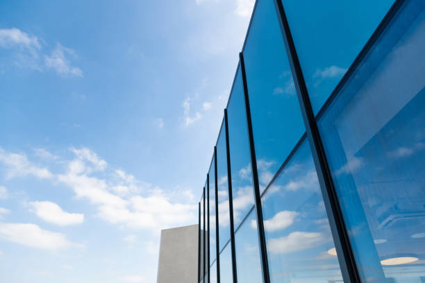 Cloud sky reflected on glass windows of modern building.