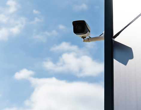 security cameras in front of blue sky - with space for text