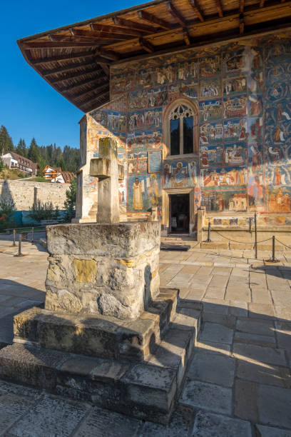 stone cross and painted facade in the voronet monastery, romania - voronet imagens e fotografias de stock