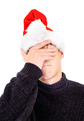 Sad Young Man in Santa Hat weeps Isolated on the White Background
