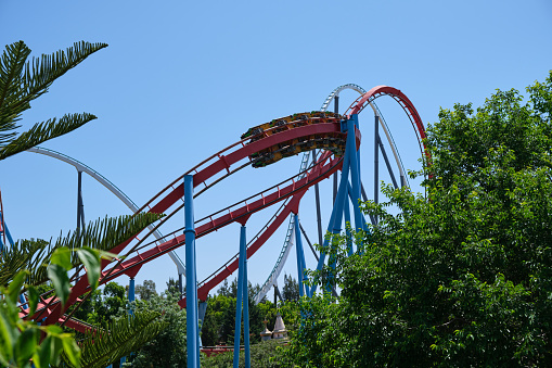 Inverted roller coaster with narrow metal rails, an ideal summer day to enjoy vacations