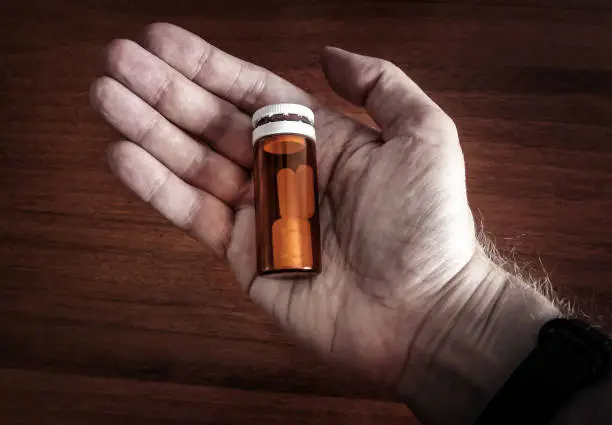 Person hold a Pills in Phial in the Hand closeup