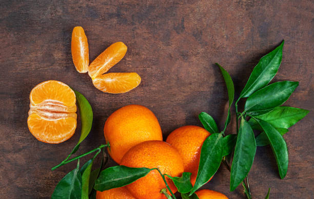 istock Fresh mandarin oranges fruit or tangerines with leaves on rustic wooden table, top view. Flat lay 1715251710