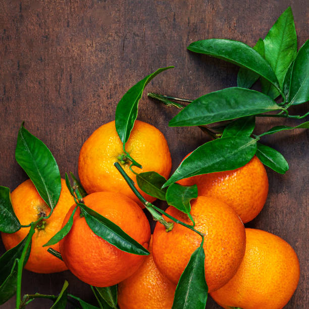 istock Fresh mandarin oranges fruit or tangerines with leaves on rustic wooden table, top view. Flat lay 1715251713