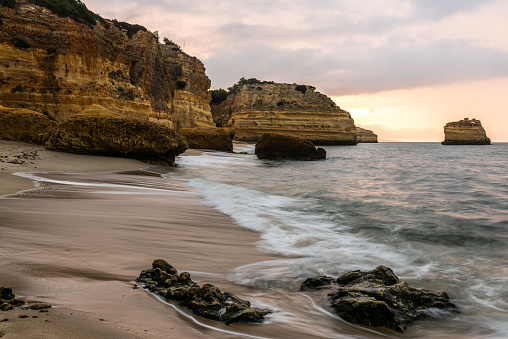 Rocky cliffs on sandy Marinha Beach in Algarve coast at Atlantic Ocean in Portugal