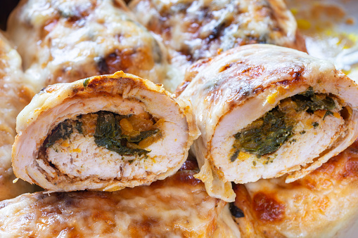 Halves of chicken rolls stuffed with spinach and carrot, cross section.