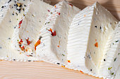 Sliced white cow cheese with herbs. Traditional food