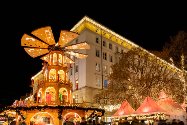 beautiful traditional german christmas market square in magdeburg city center germany with christmas pyramide many carousel, tree lights and decoration. christmas and new year celebration season - frankfurt german culture night city imagens e fotografias de stock