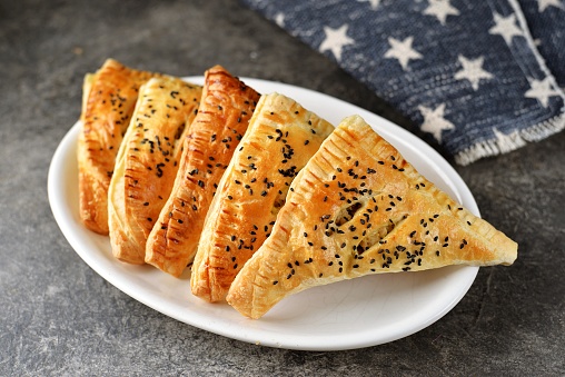 Homemade puff pastries with meat and sesame seeds.