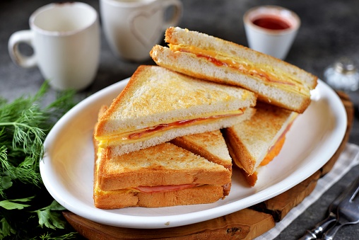 Sandwiches with egg, ham and toast cheese fried in a pan.