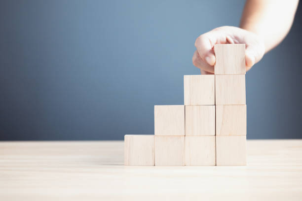 istock hand of a businessman stacking wood empty ten blocks with copy space for text or symbols, development concept for growth success process. 1715310801