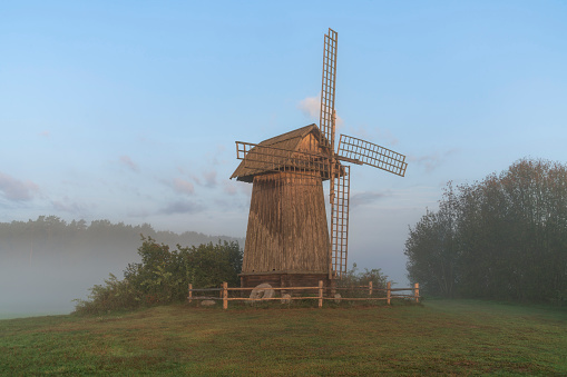View of an ancient windmill on a foggy summer morning, village Mikhailovskoye, Pushkinskiye Gory, Pskov Oblast, Russia