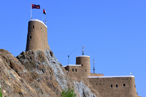 Old Muscat, Oman: Al-Mirani Fort perched on a rocky cliff - Al-mirani was built on the remains of an earlier Islamic fortification after the conquest of Muscat by the Portuguese at the beginning of the 16th century. The fortress was completed in 1587, called 
