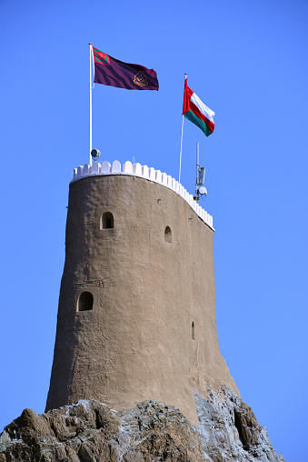 Old Muscat, Oman: keep of Al-Mirani Fort with the flags of Oman and the Sultan - Almirani was built on the remains of an earlier Islamic fortification after the conquest of Muscat by the Portuguese at the beginning of the 16th century, mainly as protection against Ottoman incursions. The fortress was completed in 1587, called 