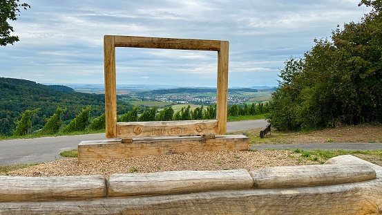 Oberstenfeld, Germany - September 21st - 2023: View of the Bottwartal valley from a hill. On the wooden frame the text „Fernsehen“ is written = television.