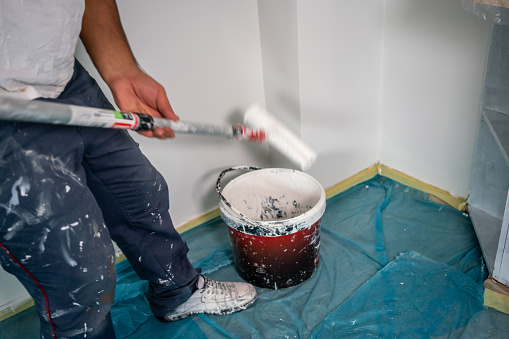 blue collar worker is painting wall with motion blur horizontal construction still