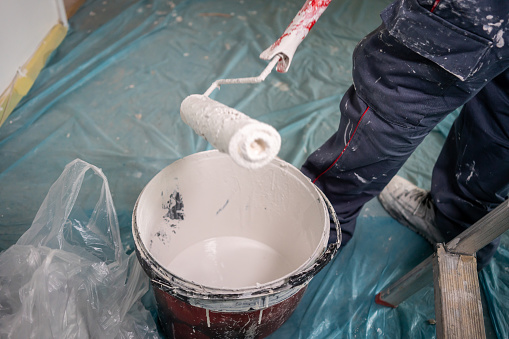 blue collar worker is painting construction horizontal still