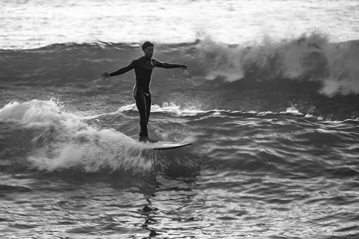 Local surfer riding waves with a short board in Furadouro beach, Portugal. Men catching waves in ocean. Surfing action water board sport.