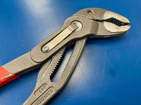 Hands holding crocodile alligator clips red and black color for electrical and electronic testing connect solder. Person measuring of tension and voltage