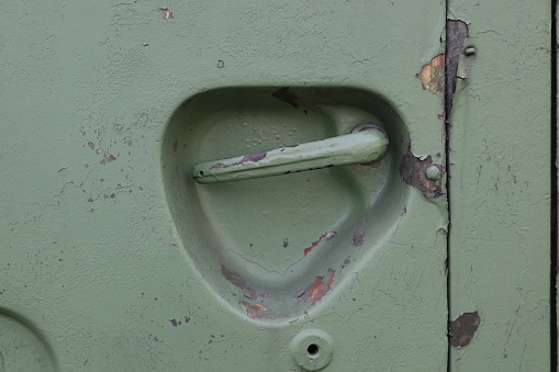 Metal door handle painted green