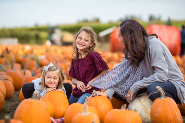 istock Mom and daughters enjoy a day at the pumpkin patch 1715453590