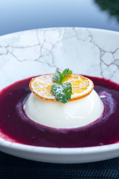 istock Panna cotta with orange slice, mint and raspberry sauce. Delicious light dessert. 1715459979