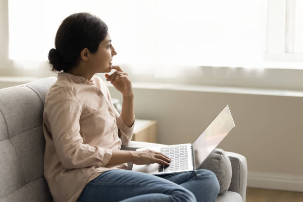 istock Thoughtful young Indian freelance woman thinking on creative ideas 1715467808