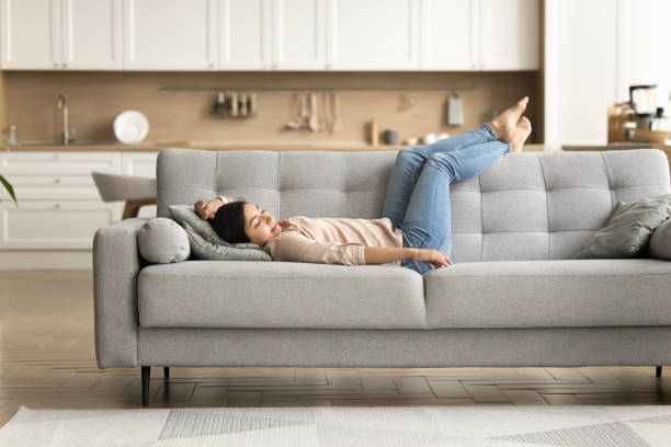 istock Peaceful relaxed young Indian woman resting on grey soft couch 1715467824