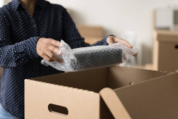 istock Female logistic worker packing parcel for shipping 1715467903
