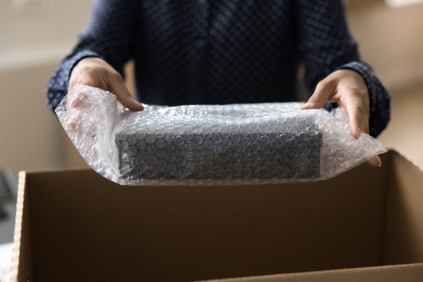 istock Young storage manager woman putting goods into cardboard box 1715467906