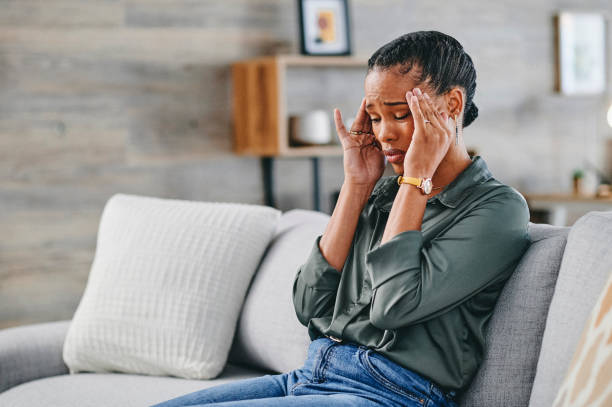 istock Woman having headache, sitting on sofa at home 1715472521